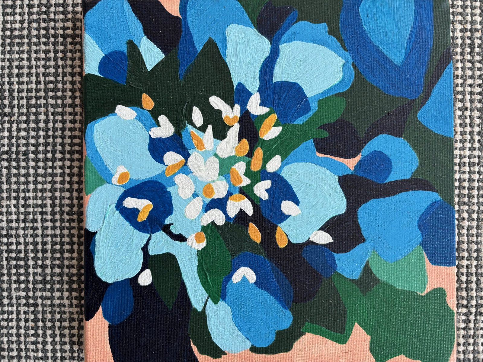 Bold abstract florals in layered shades of blue with white and ochre centres on a peach background