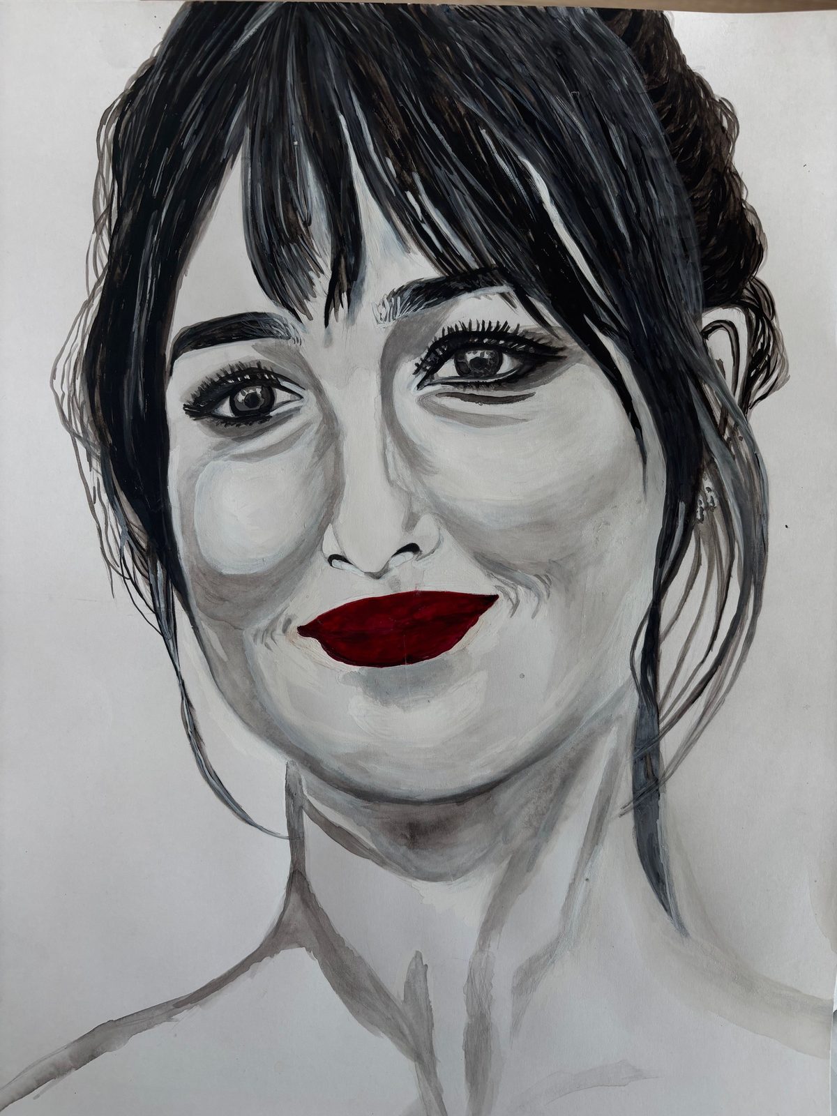 Monochrome portrait of a smiling woman with loose dark hair and striking deep red lips