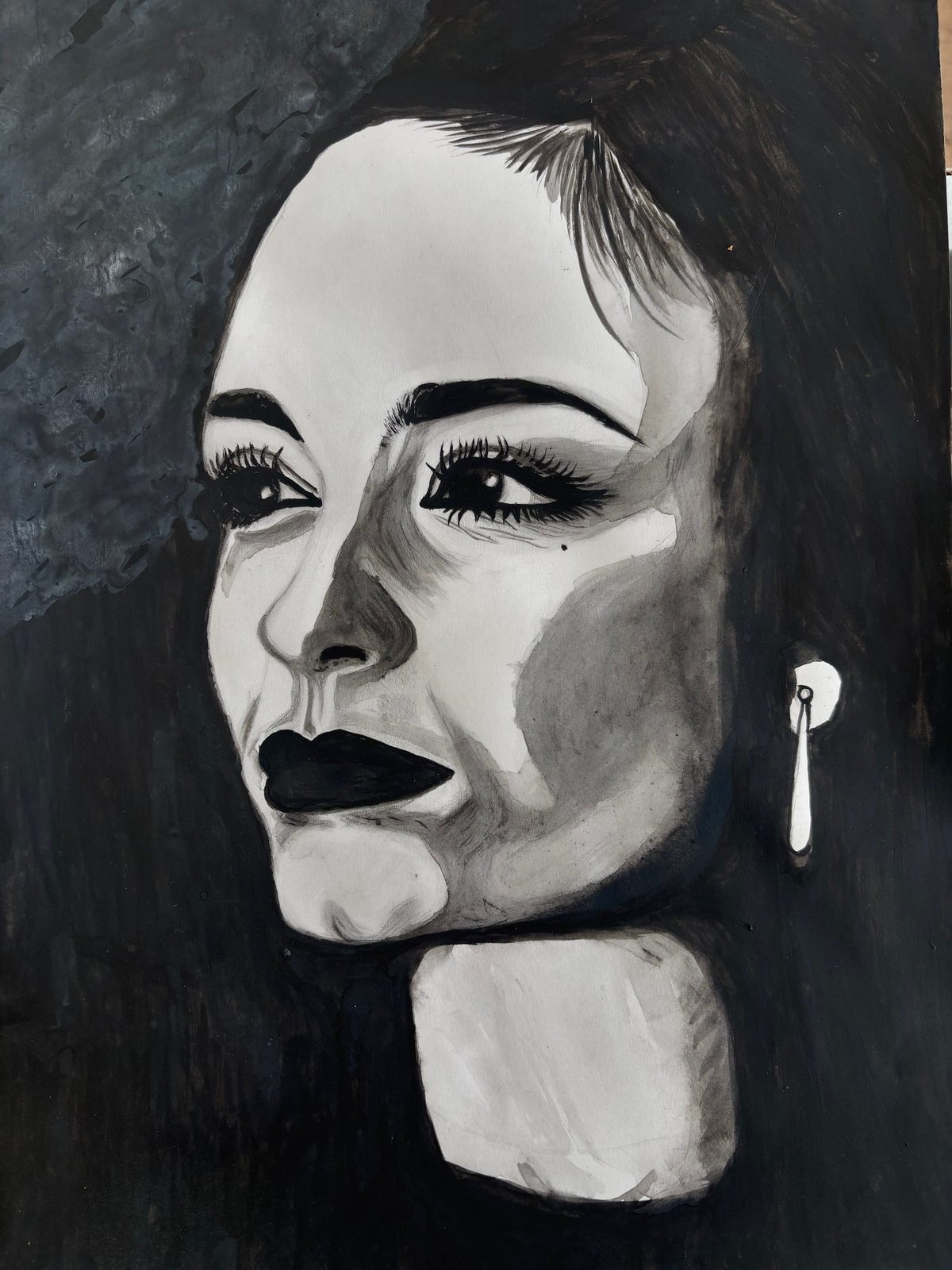 Dramatic black and white portrait of a woman gazing into the distance with dark lips and a pearl drop earring